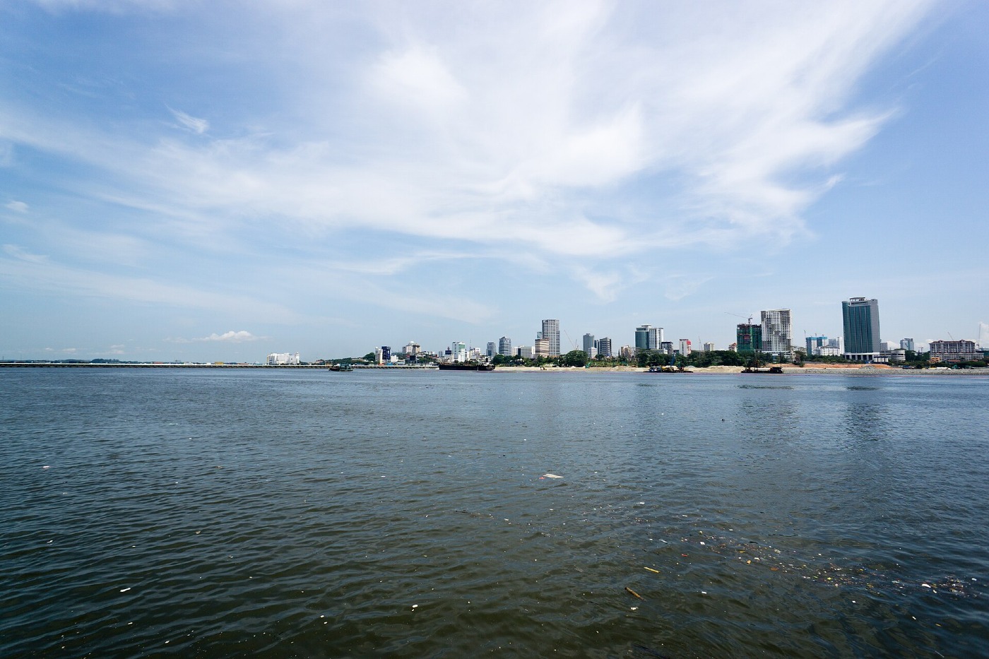 The Johor Bahru skyline across the water under a wide sky