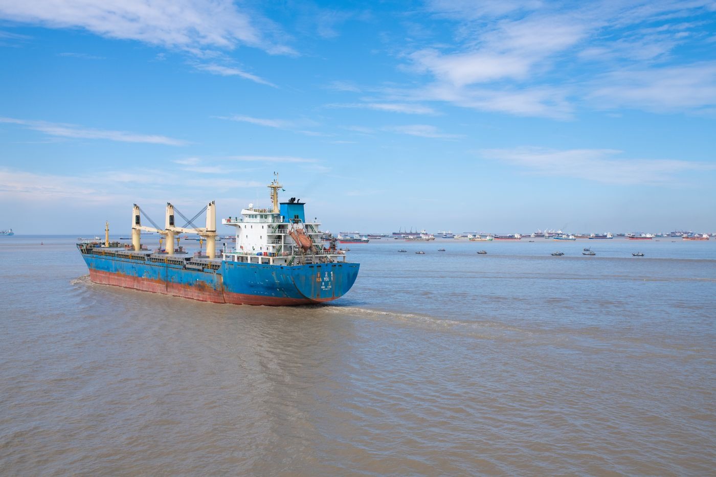 Cargo ship on the Karnaphuli River at Chattogram under a blue sky